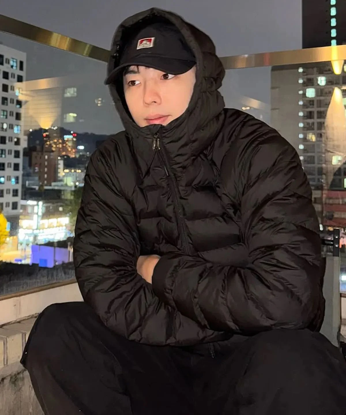 178cm 남성이 블랙 패딩 자켓을 입고 가볍게 산책하는 뒷모습, 후드가 자연스럽게 잡힌 핏