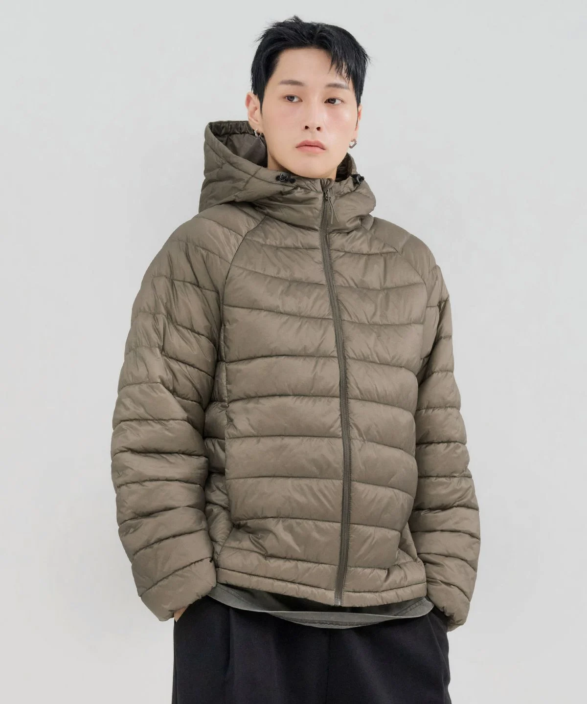 패딩 점퍼의 지퍼를 끝까지 올린 목 부분과 후드 연결 부위의 꼼꼼한 봉제선을 근접 촬영한 사진